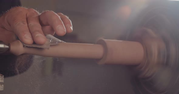 Artist creating a buddhist prayer wheel on a lathe alt
