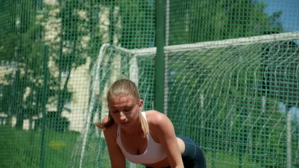 Young Athletic Caucasian Woman in Sportswear Doing Push Ups at Sports Ground