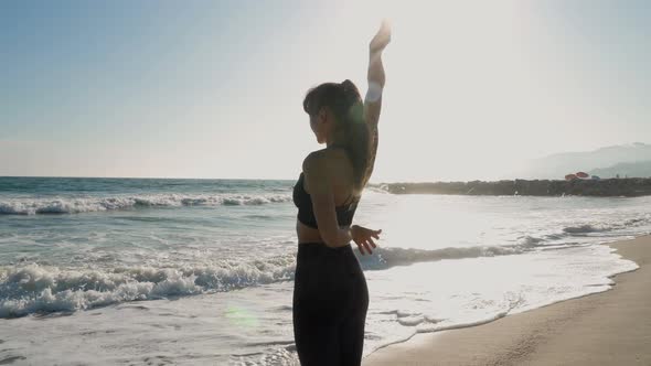 Athletic woman at the beach stretching and relaxing after her workout alt