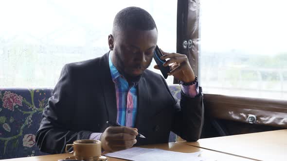 Afro American Businessman is Calling on Smartphone alt