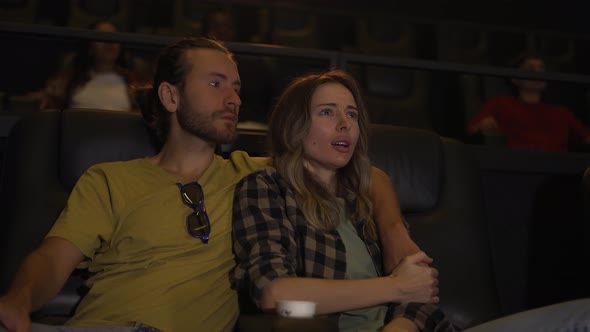 Blonde Girl Looking Scary While Watching Film Her Boyfriend Calming Her Down alt