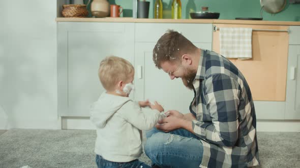 Father and Son Playing on Floor with Shaving Foam alt