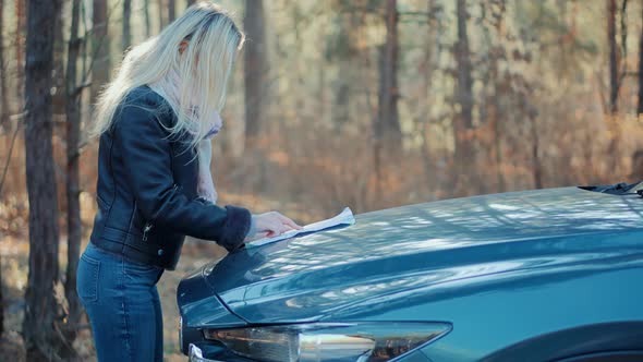 Woman Walking Away Alone On Forest Path. Hiking Woodland  In Autumn Fall.  Walking On Woods With Map alt