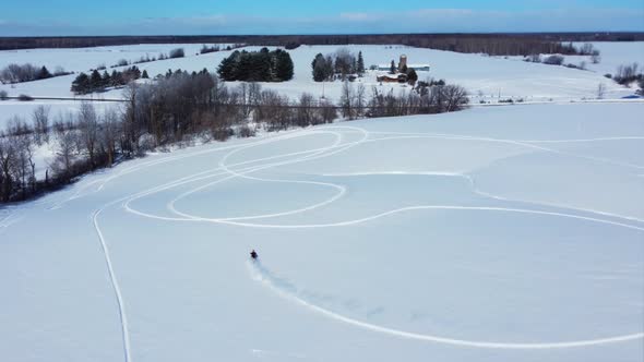 snowbike aerial rider carving the open fields and hills in fresh powder alt