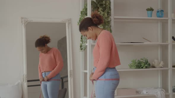 Lovely Positive Female Measuring Her Hips Indoors alt