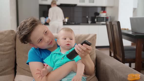 Woman Preparing Food While Her Two Sons Playing Together alt