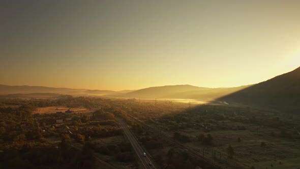 Cinematic Aerial Drone View of Hazy Mountain Walley at Sunrise alt