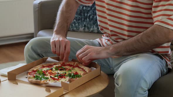 Man Opening Box and Eating Takeaway Pizza
