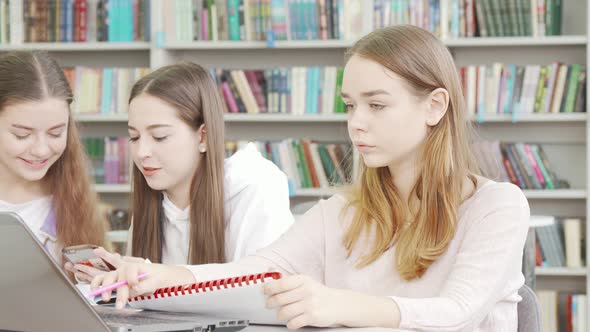 Teen Schoolgirl Working on an Assignment at the Library alt