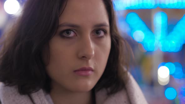 young thoughtful woman looking at camera - outdoors alt