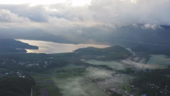 Aerial Drone View of Sunrise Over Misty River alt