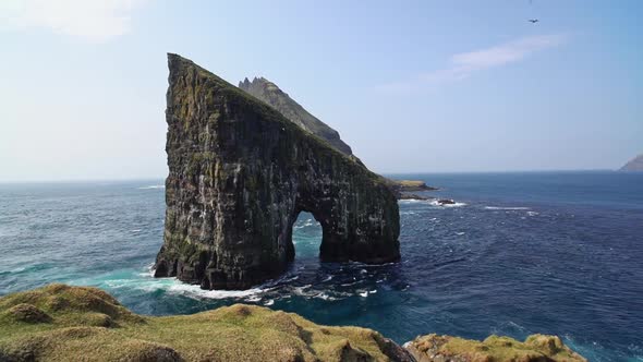Man with Camera and Tripod Setup By the Cliff Taking Drangarnir Photograph alt