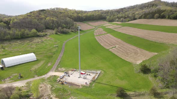 Example of strip farming in a rural valley with bluffs and forest, farm buildings and cell tower.