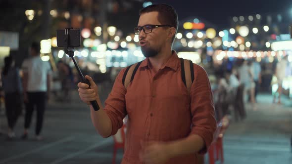 Man Having a Video Chat on Mobile Outdoor at Night alt