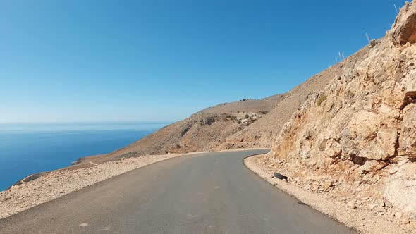 Coast POV driving in the mountains on a sunny summer day. Zig-zag curve road and U-turns in a desert alt
