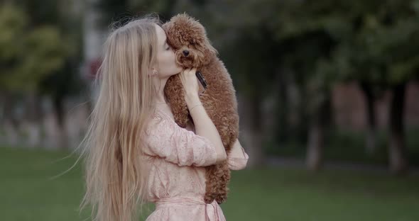 Beautiful young girl holding a dog in her arms