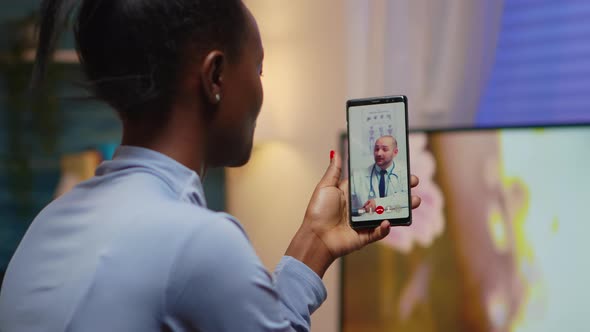 African Famele Having Conference Call with Her Doctor alt