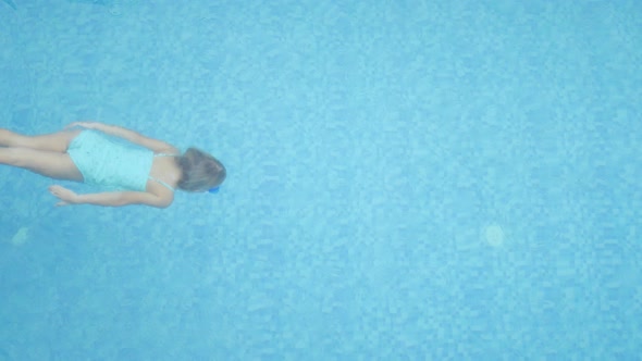 Girl Child Swims in the Pool Underwater View of the Pool From Above alt