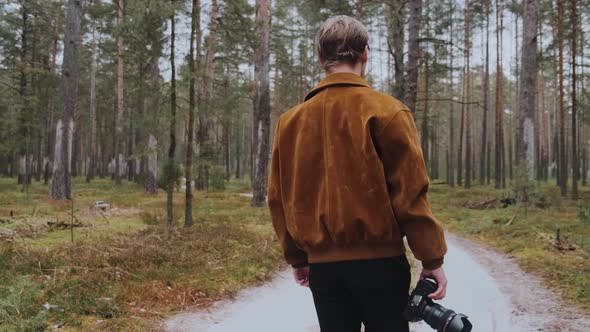 A Young Blond Male Photographer Takes Pictures of Nature alt