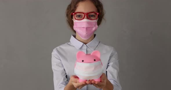 Businesswoman wearing medical mask holding piggy bank