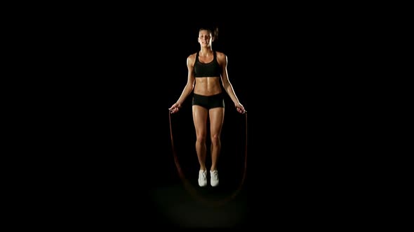 Young Athletic Woman Wearing Sporstwear is Jumping Skipping Rope Slow Motion