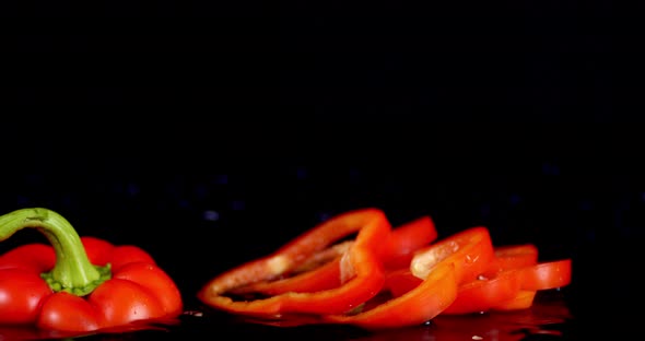 Sliced Red Sweet Pepper Falling Into Water with a Splash.  alt