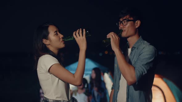 Couple Asia teenagers drinking have fun salute toast of bottle beer enjoy party with happy at night.