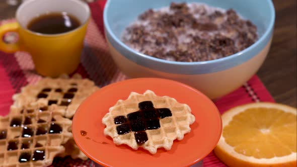 Pouring topping over rotating waffle 