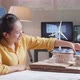 Side View Of Asian Woman Being Happy Succeed Building A Model Of Small House With Solar Panel - VideoHive Item for Sale