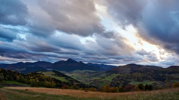Autumn rural landscape at dusk. Thick clouds at sunset. Colorful trees in autumn. alt