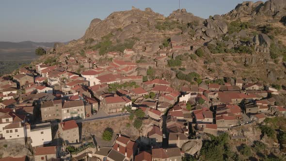Monsanto village perched on mountain, Portugal. Aerial drone backward ascending alt