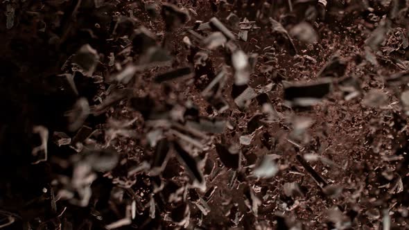 Super Slow Motion Shot of Raw Chocolate Chunks and Cocoa Powder Exploded Towards Camera at 1000Fps alt