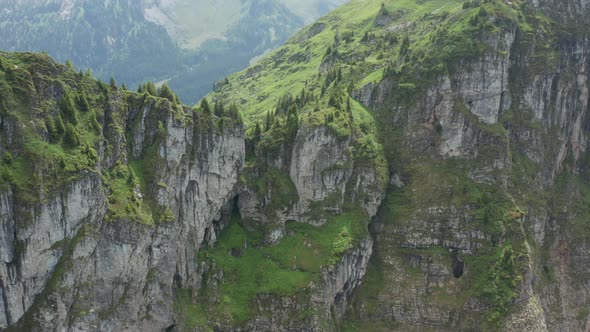 Flying towards a beautiful green mountain top in Switzerland alt