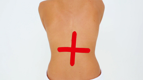 Woman Having Red Kinesio Tape Applied To Back