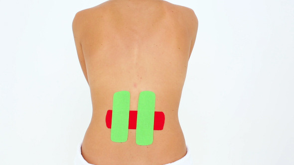 Woman Having Red And Green Kinesio Tape Applied