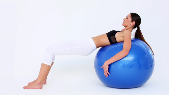 Fit Woman Doing Pelvic Lifts On Blue Exercise Ball