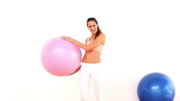 Fit Model Holding Exercise Ball And Smiling