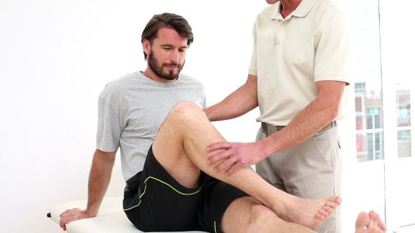 Physical Therapist Checking Injured Patients Knee