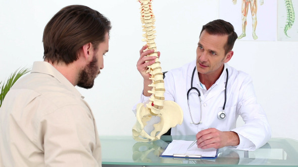 Doctor Showing His Patient A Skeleton Spine Model