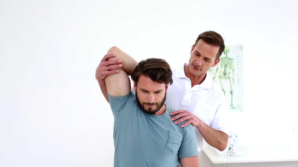 Physiotherapist Stretching Patients Shoulder