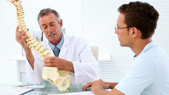 Mature Doctor Speaking To His Patient About Spine