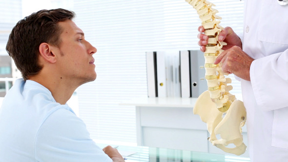 Patient Listening To His Doctor Explain Spine