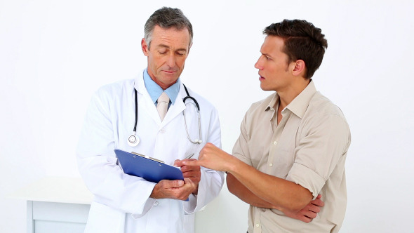 Patient Talking To His Doctor Holding Clipboard