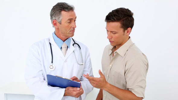 Patient Speaking To His Doctor Holding Clipboard