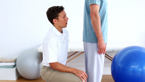 Physiotherapist Checking The Lower Back Of Patient