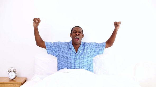 Happy Man Yawning And Stretching Sitting In Bed 2