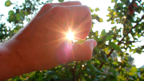 Hand Catches Sun In A Fist