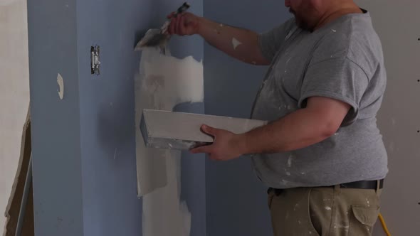 Handyman Using Tool Plastering for Finishing Old Wall alt