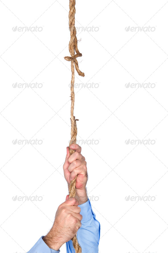 Businessman hanging from frayed rope