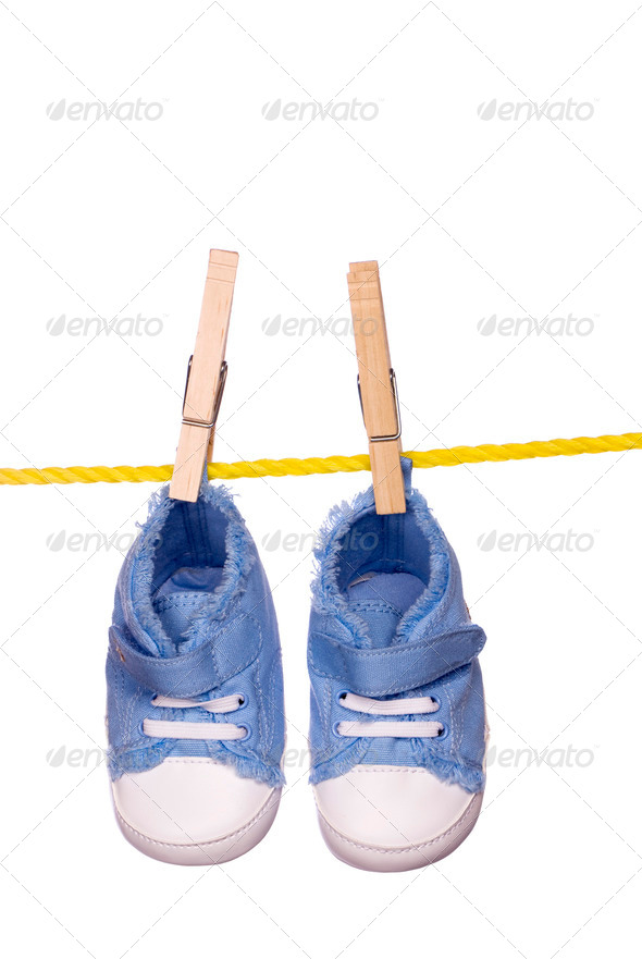 Baby shoes hanging on a clothesline - Stock Photo - Images